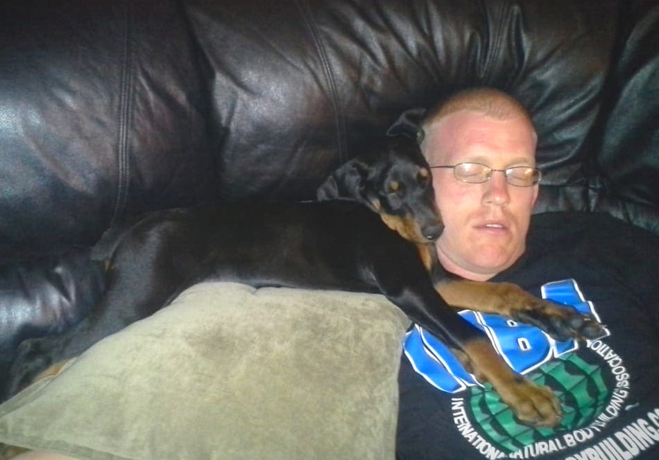 Sleeping Doberman puppy with his owner.